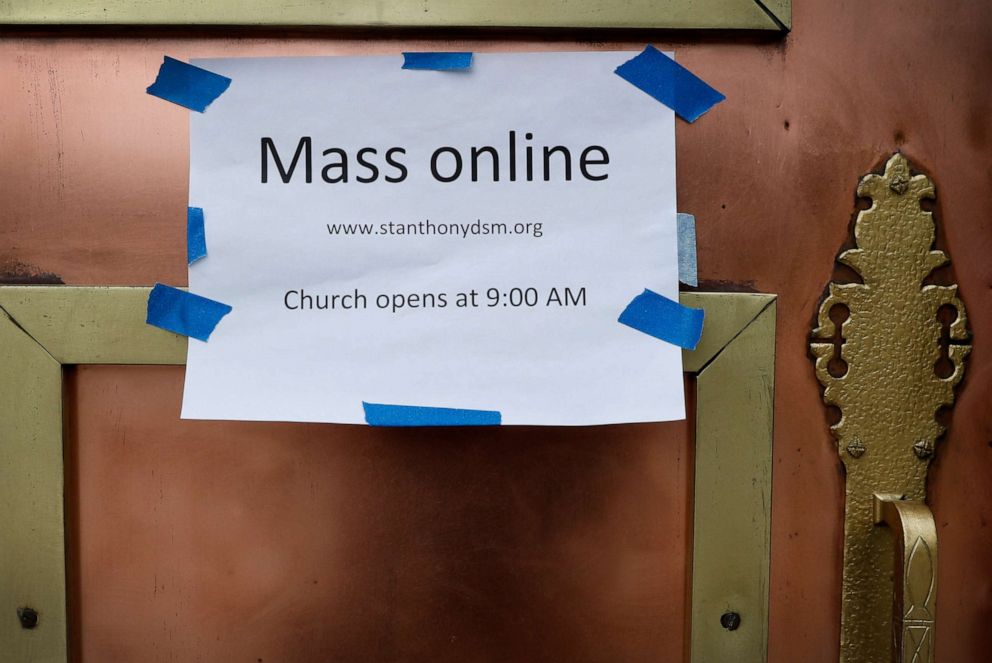 PHOTO: A sign on the front door of the St. Anthony's Catholic Church directs parishioners to the availability of online mass, Friday, March 27, 2020, in Des Moines, Iowa. 