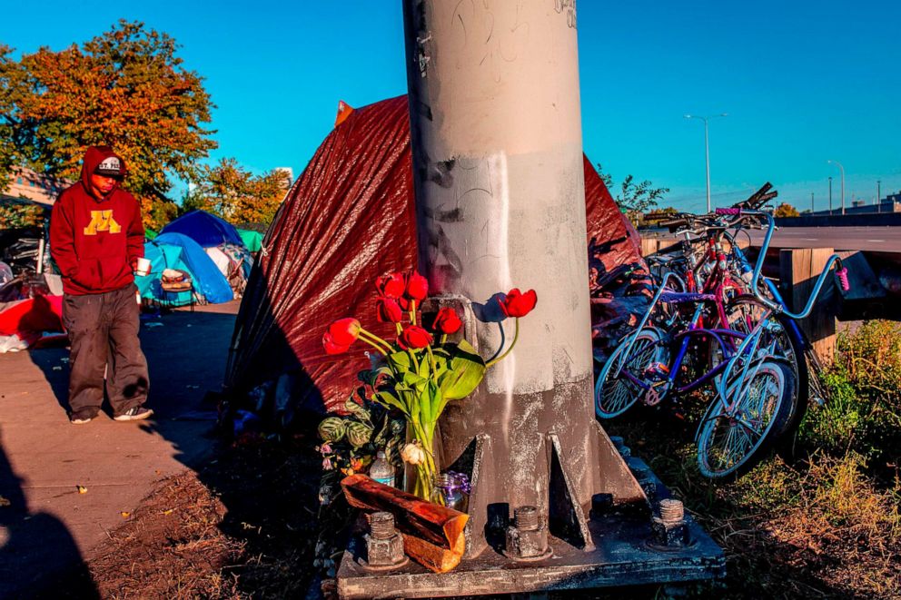 PHOTO: Flowers in memory of people who died from opioid overdoses are seen at the large encampment along Hiawatha and Cedar Avenues in Minneapolis, Minn. on Oct. 21, 2018. Most of the more than 200 people in this tent city are Native Americans.