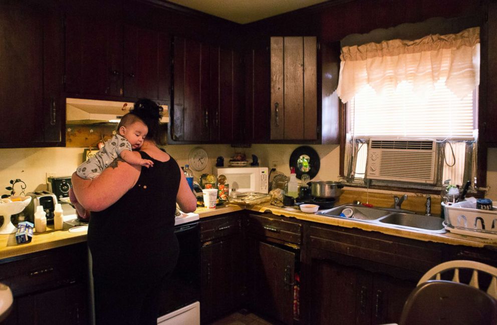 PHOTO: Deborah Crowder holds her grandson Jaydain while she cooks dinner for her family.