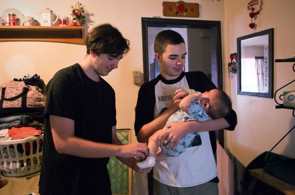 PHOTO: Tera's oldest children, twins Jacob and Jeremy care for their baby brother Jaydain at home in mid-December.
