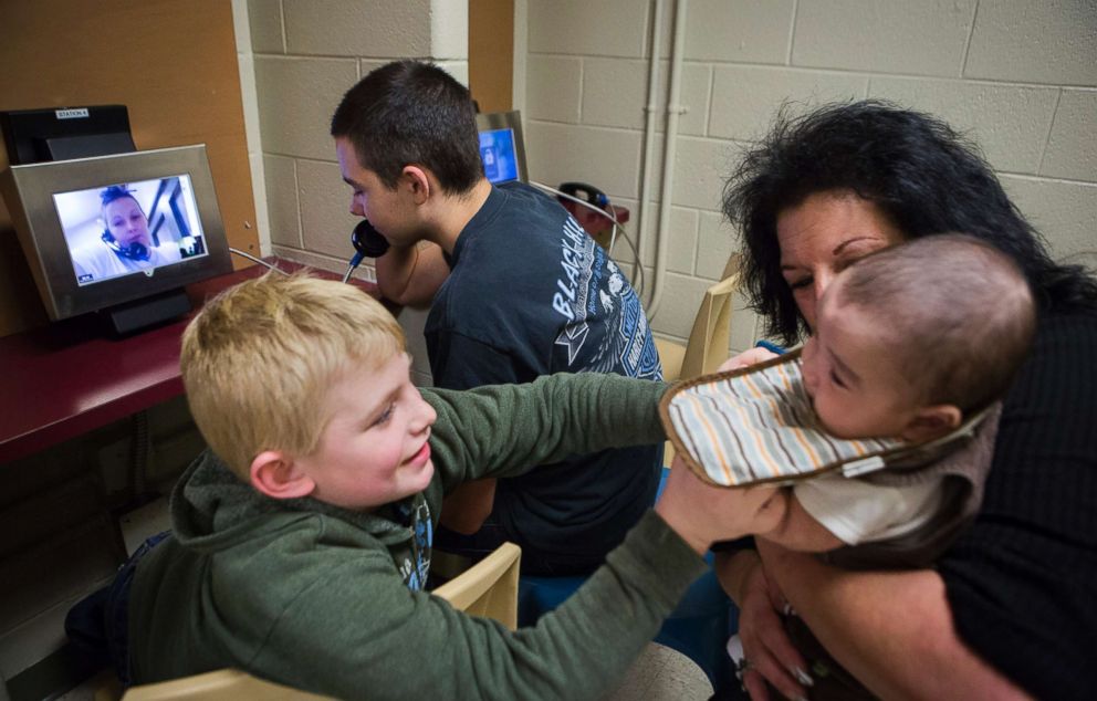 PHOTO: Jeremy talks with his mother Tera while James plays with Jaydain in his grandmother Deborah Crowder's arms during a video visit with their mother, Tera, at the Chesterfield County Jail. 