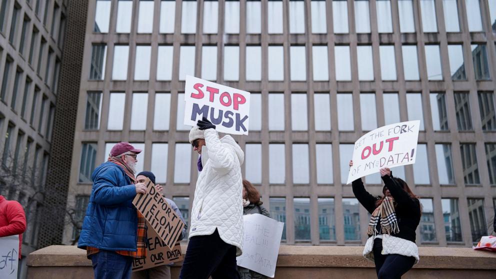PHOTO: People gather to protest outside the headquarters of the Office of Personnel Management after the Elon Musk-led Department of Government Efficiency was charged with oversight of OPM, in Washington, Feb. 2, 2025.