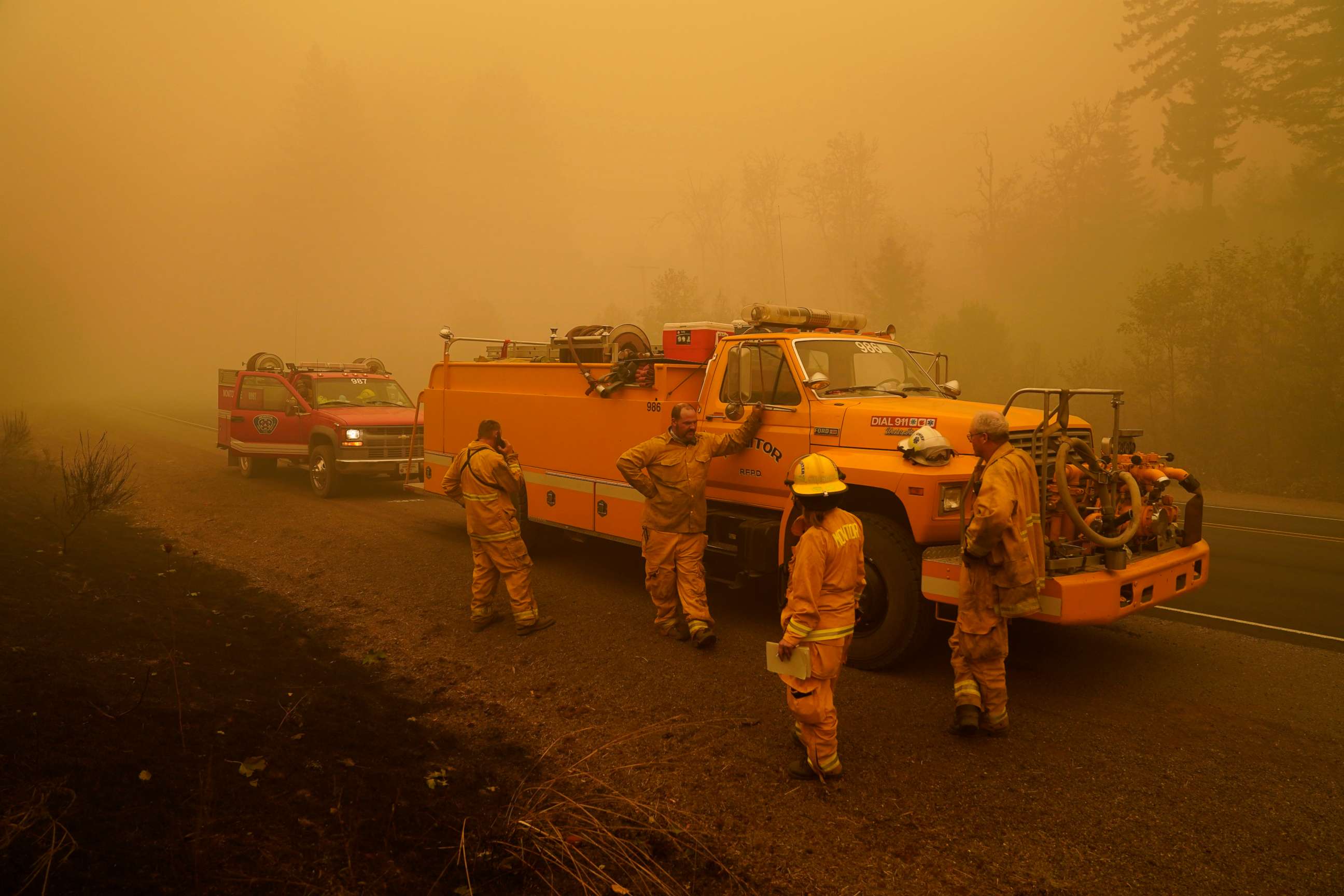 PHOTO: Firefighters with the Monitor Fire Department wait alongside the road surrounded by smoke in an area destroyed by a wildfire Saturday, Sept. 12, 2020, near Mill City, Ore. 
