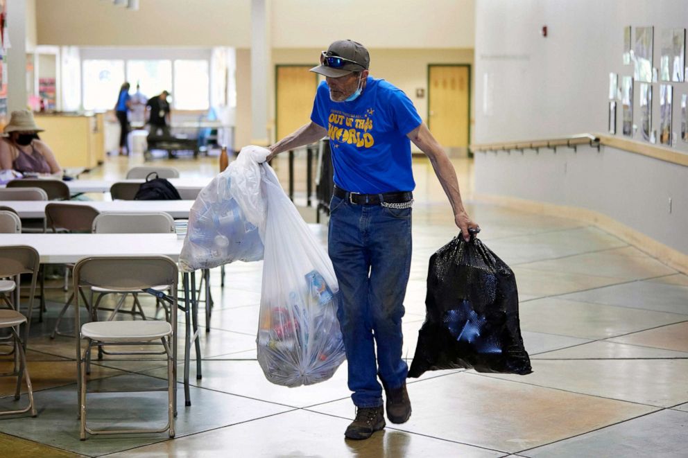 PHOTO: Rory Lidster, 55, carries in his belongings after checking into a cooling center in Portland, Ore., July 26, 2022.