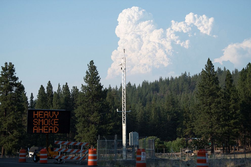 PHOTO: A traffic signal board displays a warning message, as smoke from the Bootleg Fire billows to the north, while extreme heat and wildfires continue in Klamath Falls, Oregon, July 12, 2021.
