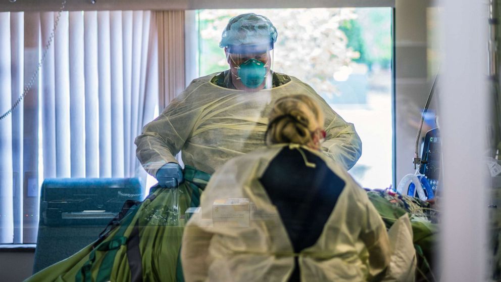 PHOTO: Spc. Blaine Williams of 1st Battalion, 186th Infantry Regiment, Oregon National Guard, helps health care technician Heather Smith change a COVID patient bedding at Mercy Medical Center ICU in Roseburg, Ore., Aug. 21, 2021.