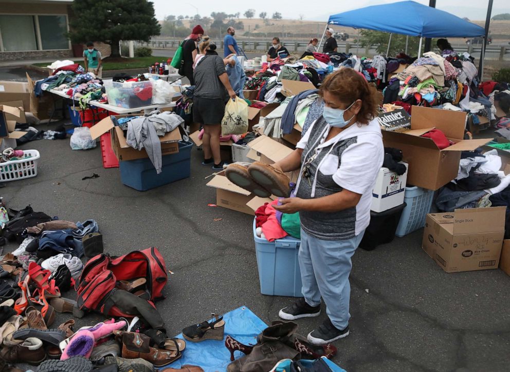 PHOTO: Maria Arevalo searches for donated clothing after her home, in a largely Latino neighborhood, was destroyed by a wildfire that came through the area in Phoenix, Ore., Sept. 22, 2020.