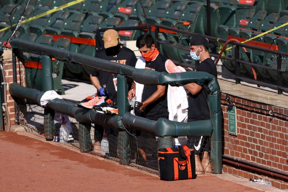 PHOTO: Staff members of the Baltimore Orioles clubhouse clean players shoes in the photo well before the start of the Orioles and New York Yankees game at Oriole Park at Camden Yards on July 29, 2020 in Baltimore.