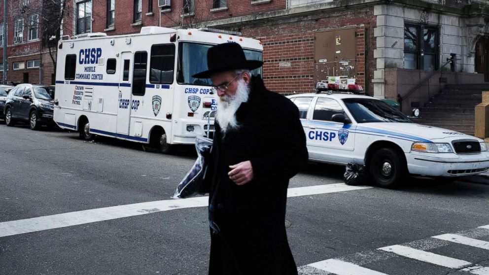 An Orthodox Jewish man walks past a security vehicle in the neighborhood of Crown Heights, Feb. 25, 2019, in New York City.