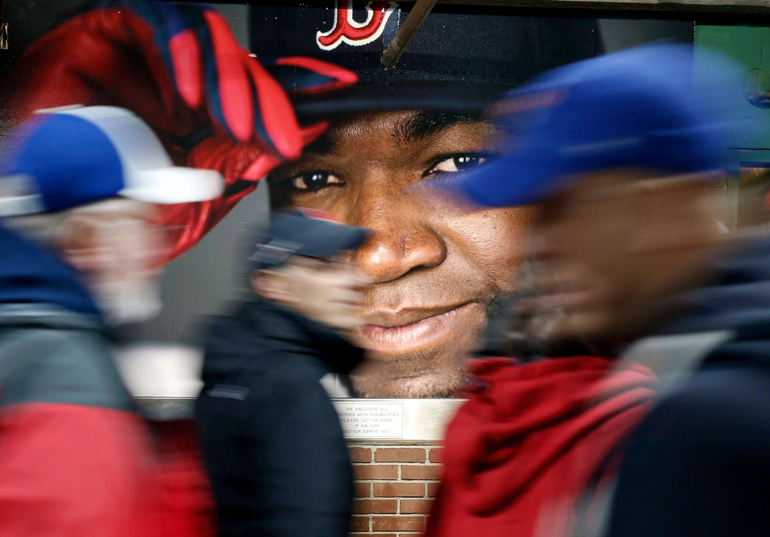 PHOTO: Fans at walk past a photograph of Boston Red Sox's David Ortiz before a baseball game at Fenway Park in Boston, Oct. 1, 2016.