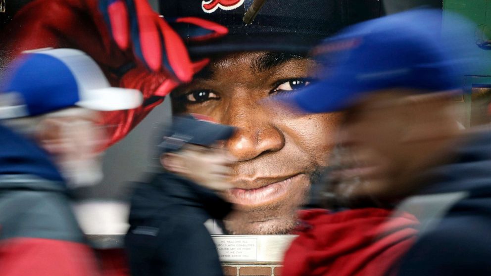 PHOTO: Fans at walk past a photograph of Boston Red Sox's David Ortiz before a baseball game at Fenway Park in Boston, Oct. 1, 2016.
