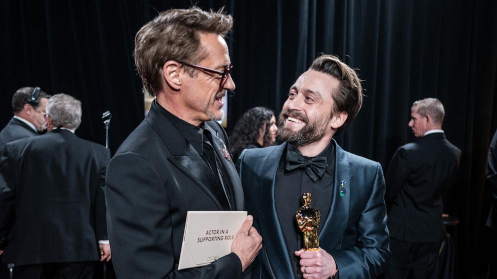 PHOTO: Kieran Culkin winner of the award for Best Actor in a Supporting Role celebrates backstage with presenter Robert Downey Jr. during the 97th Annual Oscars, Mar. 2, 2025 in Los Angeles. 