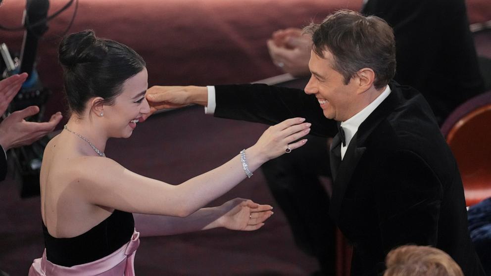 PHOTO: Mikey Madison embraces Sean Baker after he won the award for best original screenplay for "Anora" during the Oscars, Mar. 2, 2025, in Los Angeles.