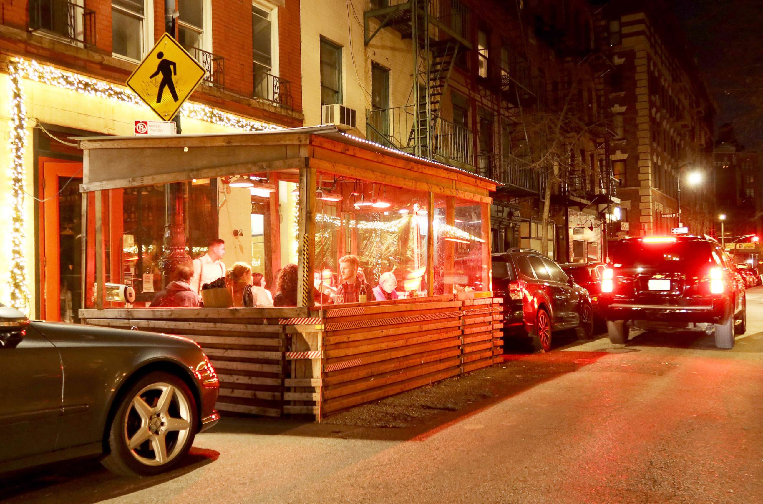 PHOTO: People eat dinner in an outdoor sidewalk shed at a restaurant on Bedford Street in Greenwich Village area of New York, Dec. 17, 2021.