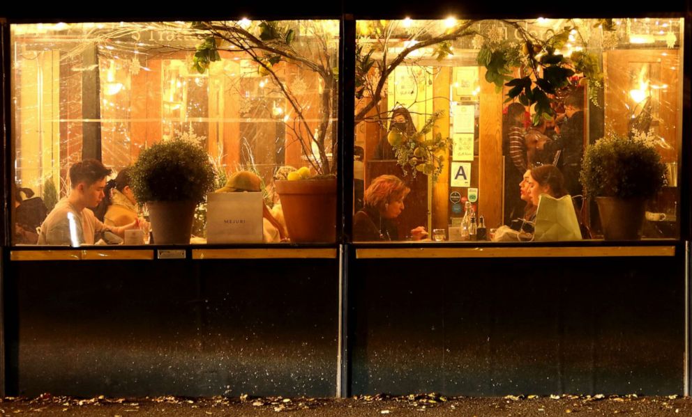 PHOTO: People eat dinner in an outdoor sidewalk shed at a restaurant in the Soho neighborhood of New York, Dec. 17, 2021. 