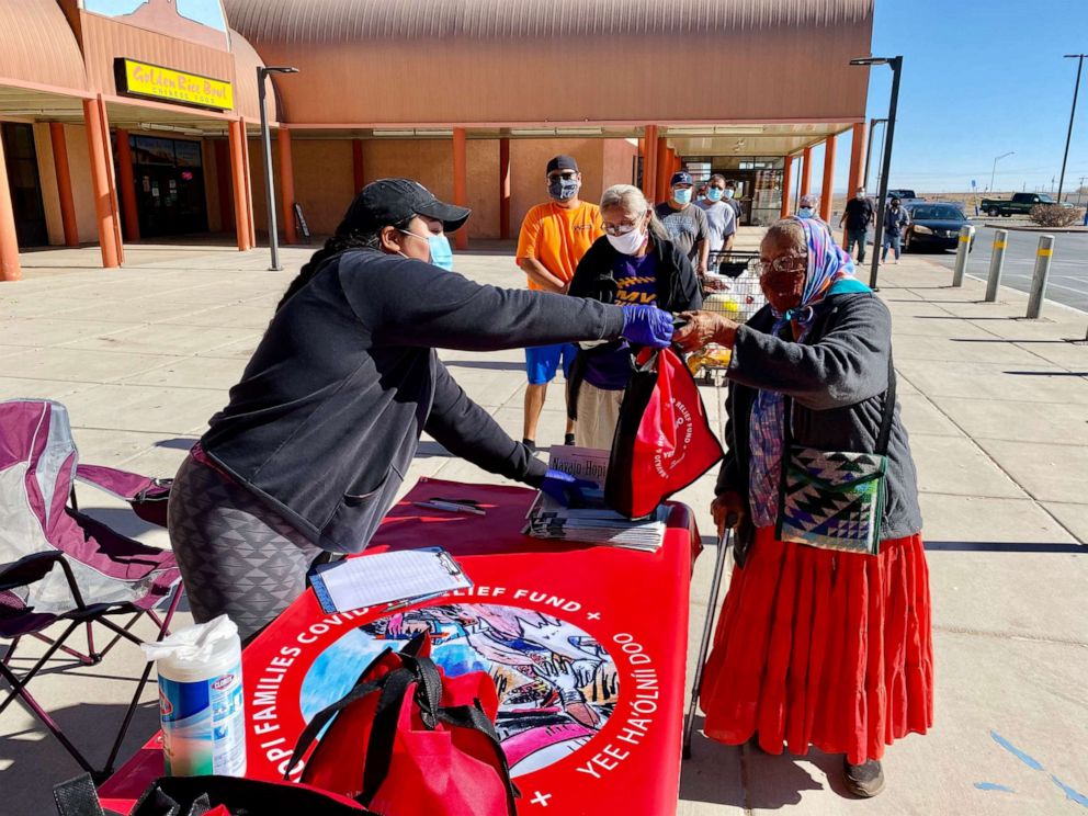 PHOTO: Shandiin Herrera helping a woman during a Navajo & Hopi Families COVID Relief event.