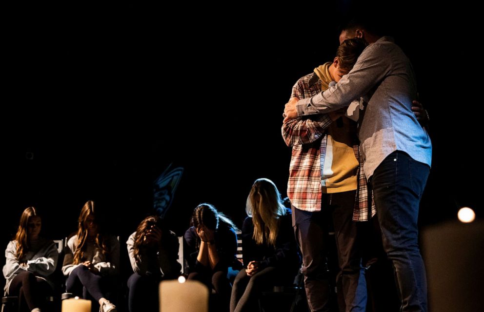 A student embraces a Bridgewood Youth Pastor after saying a prayer for the community during a candlelight prayer vigil at Bridgewood Church, after the Nov. 30 deadly shooting at Oxford High School in Oxford, Mich., in Clarkston, Mich., Dec. 1, 2021.