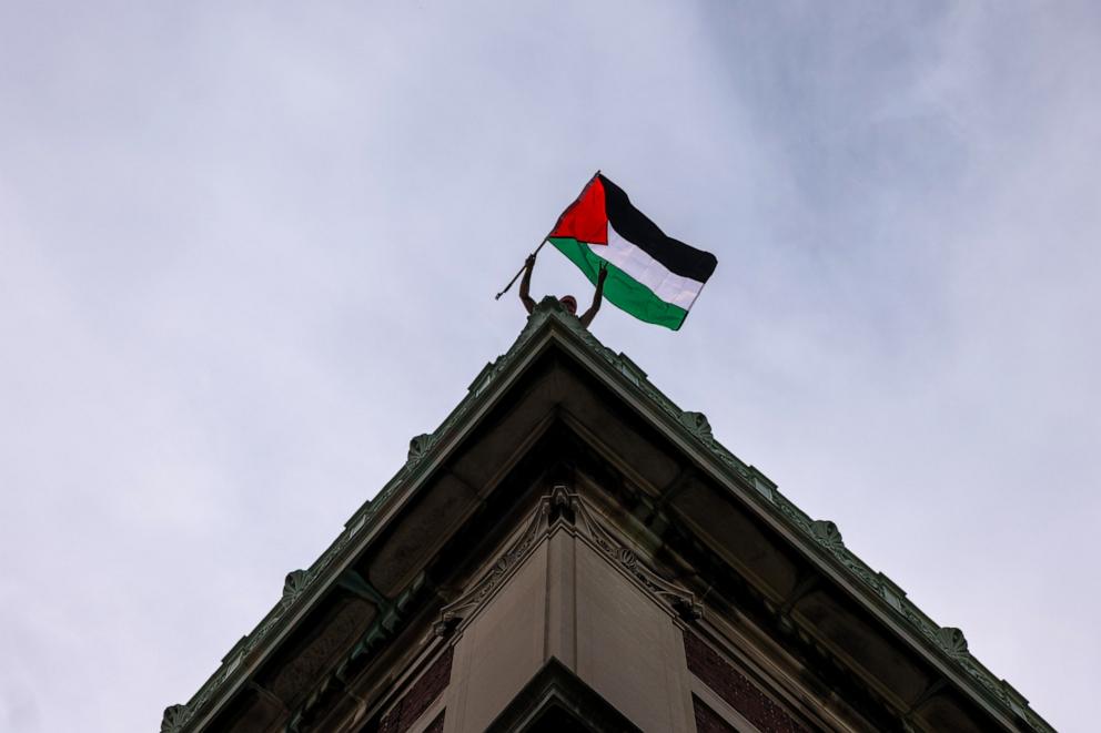 PHOTO: A Pro-Palestinian supporter waves a Palestinian flag from the roof of Hamilton Hall as they continue to demonstrate with a protest encampment on the campus of Columbia University on April 30, 2024 in New York City. 