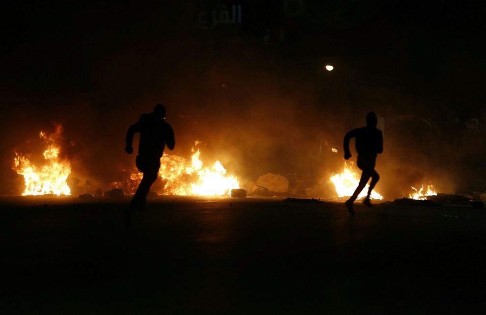 PHOTO: Palestinian demonstrators run away from the gas fired by Israeli soldiers during an anti-Israel protest over tension in Jerusalem, near the Jewish settlement of Beit El near Ramallah, in the occupied West Bank, May 12, 2021.