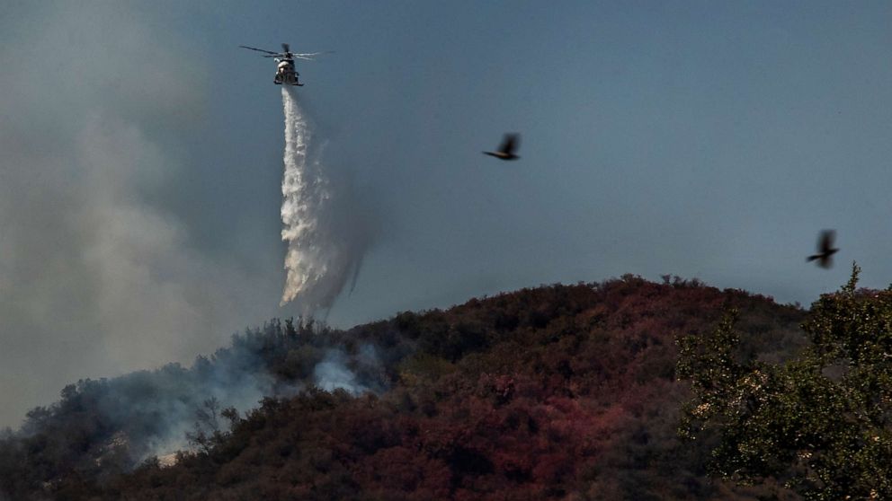 PHOTO: Firefighters battle a brush fire from a helicopter in Pacific Palisades in California, May 17, 2021.