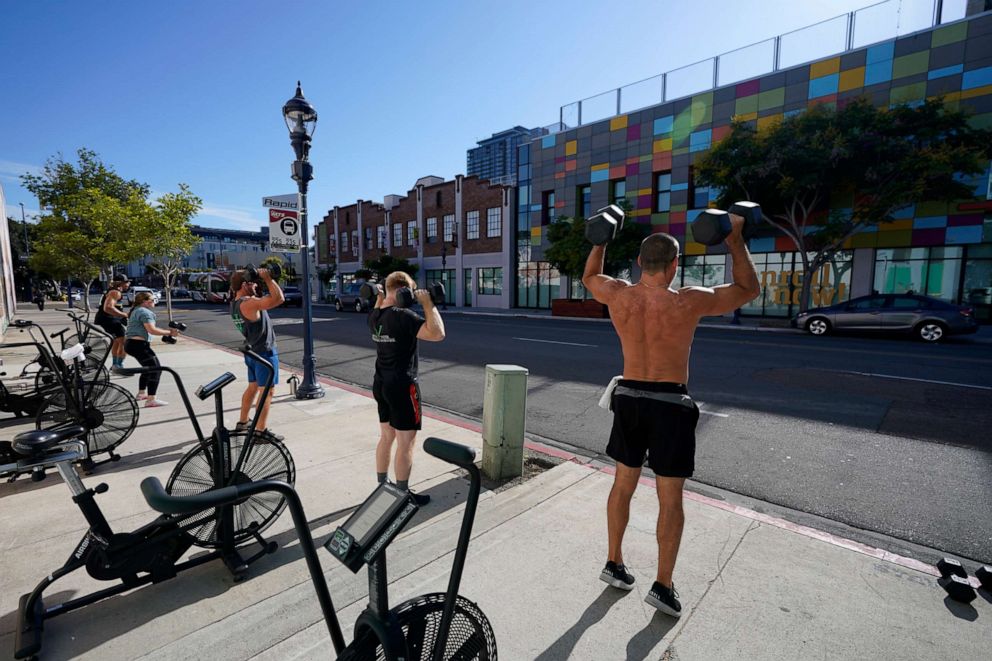 PHOTO: People lift weights outdoors while training at a gym in San Diego, Aug. 12, 2020.