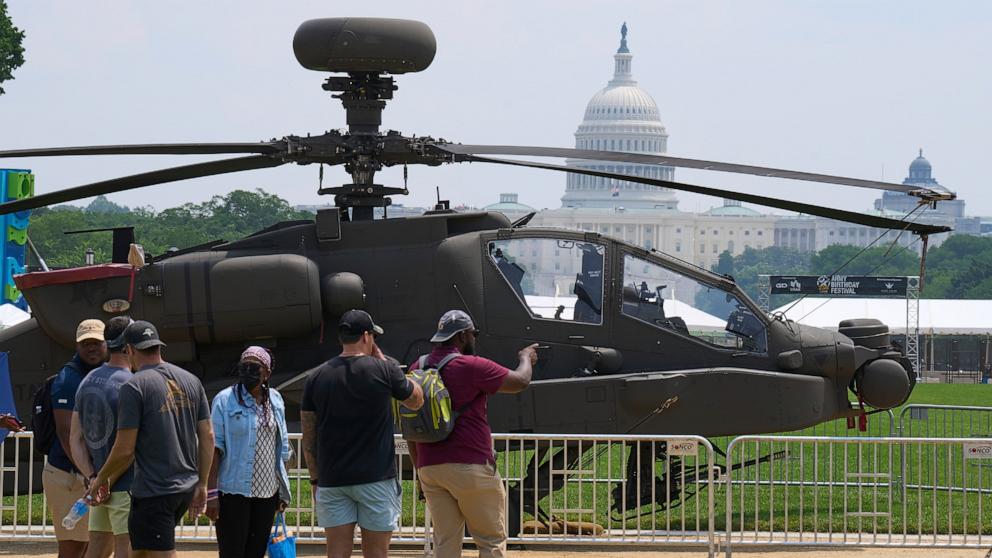 PHOTO: People look at a military helicopter with the Capitol in the background, June 13, 2025, on the National Mall in Washington.
