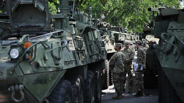 Soldiers stand between columns of Stryker armored vehicles taking part in the Army's 250th birthday celebration parade during a preview at West Potomac Park in Washington, June 11, 2025. 