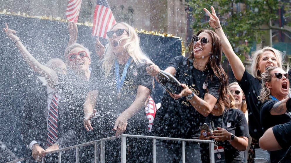 PHOTO: U.S. Women's soccer player Alex Morgan sprays champagne into the crowd during a ticker tape parade celebrating the team's 2019 World Cup victory in New York City, July 10, 2019.
