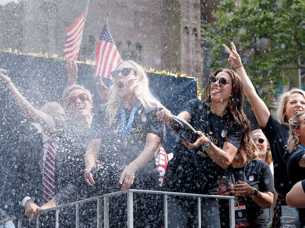 PHOTO: U.S. Womens soccer player Alex Morgan sprays champagne into the crowd during a ticker tape parade celebrating the teams 2019 World Cup victory in New York City, July 10, 2019.