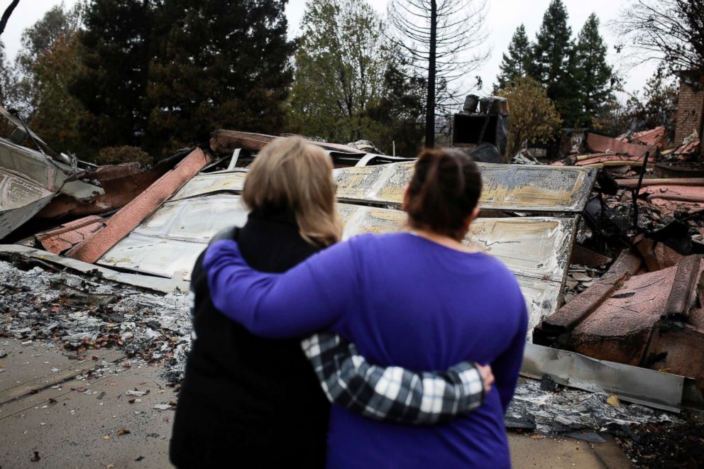  Two neighbors comfort each other in front of the remains of a home after the two returned for the first time since the Camp Fire in Paradise, Calif., Nov. 22, 2018. 