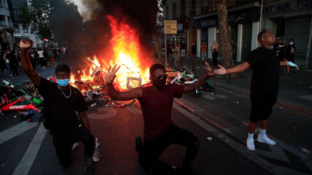 PHOTO: Protesters kneel and react by a burning barricade during a demonstration Tuesday, June 2, 2020 in Paris.
