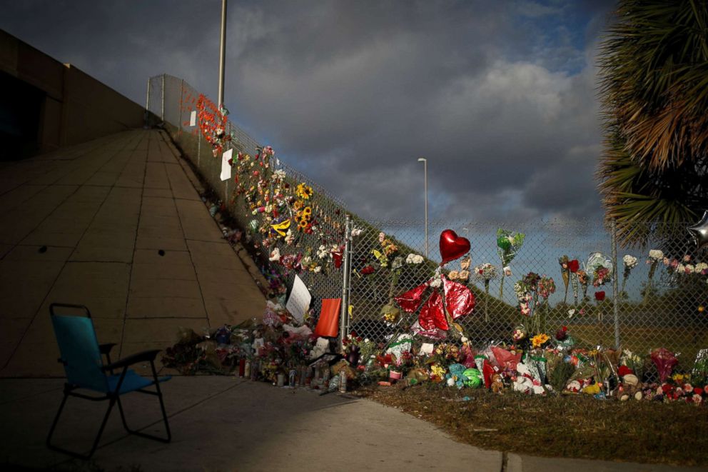 PHOTO: An empty chair is seen in front of flowers and mementos placed on a fence to commemorate the victims of the mass shooting at Marjory Stoneman Douglas High School, in Parkland, Florida, Feb. 20, 2018.