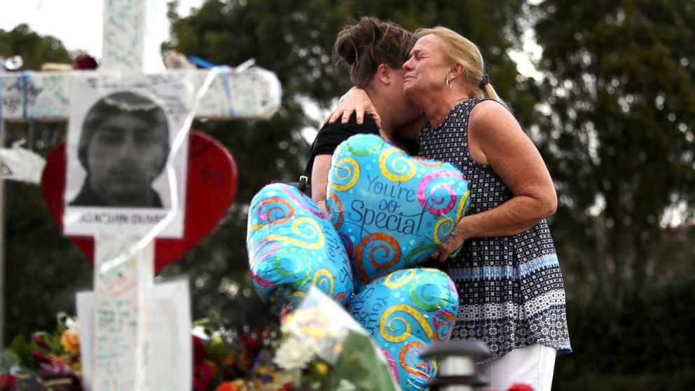 PHOTO: Cindy Sotelo (R) cries with her daughter, Jessica Malone, an alumna of Marjory Stoneman Douglas High School, as they visit a makeshift memorial setup in front of the school, Feb. 19, 2018 in Parkland, Fla.