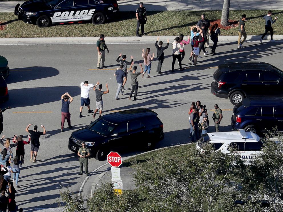 PHOTO: Students hold their hands in the air as they are evacuated by police from Marjory Stoneman Douglas High School in Parkland, Fla., Feb. 14, 2018, after a shooter opened fire on the campus.