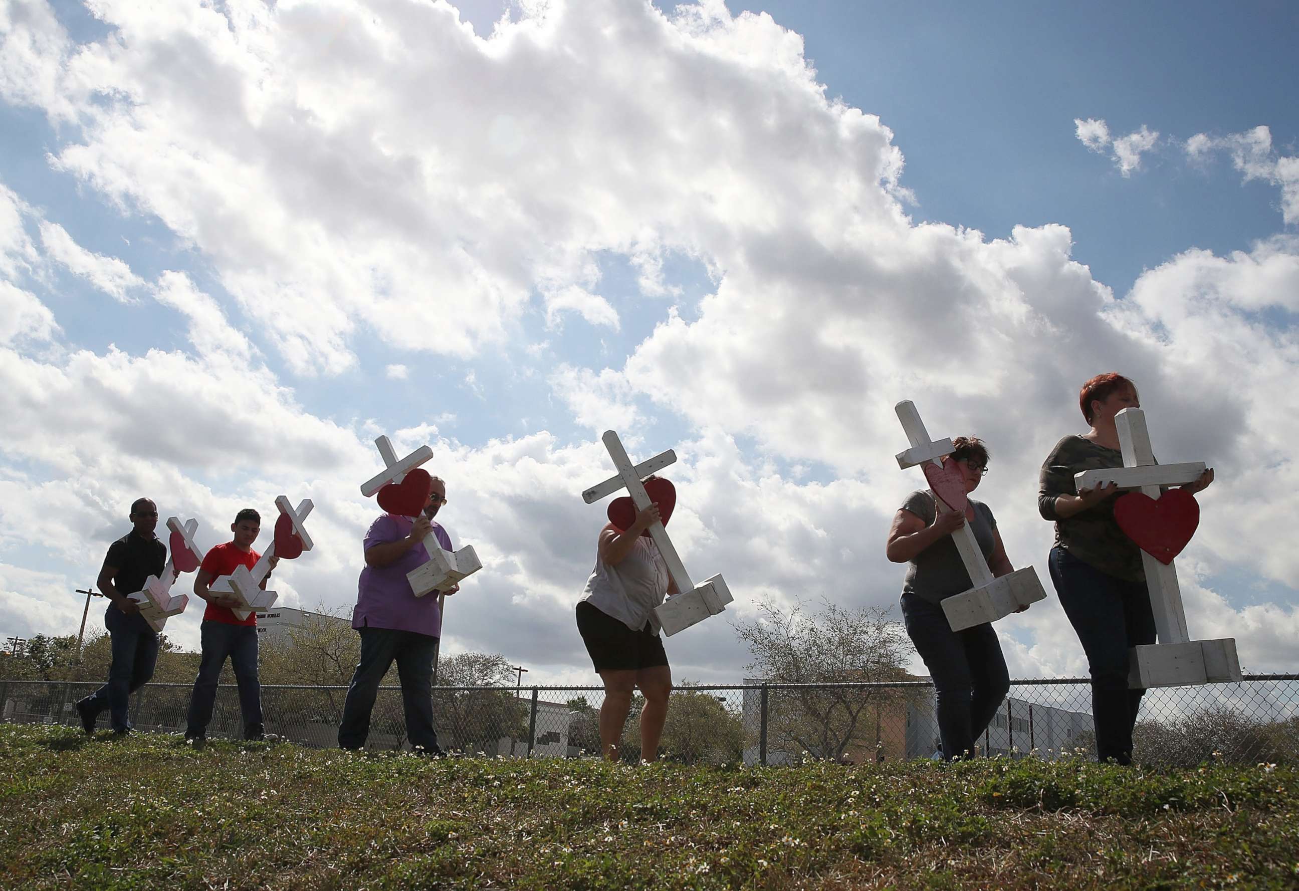 PHOTO: Volunteers carry crosses to be placed in front of the Marjory Stoneman Douglas High School, Feb. 18, 2018, in Parkland, Fla.
