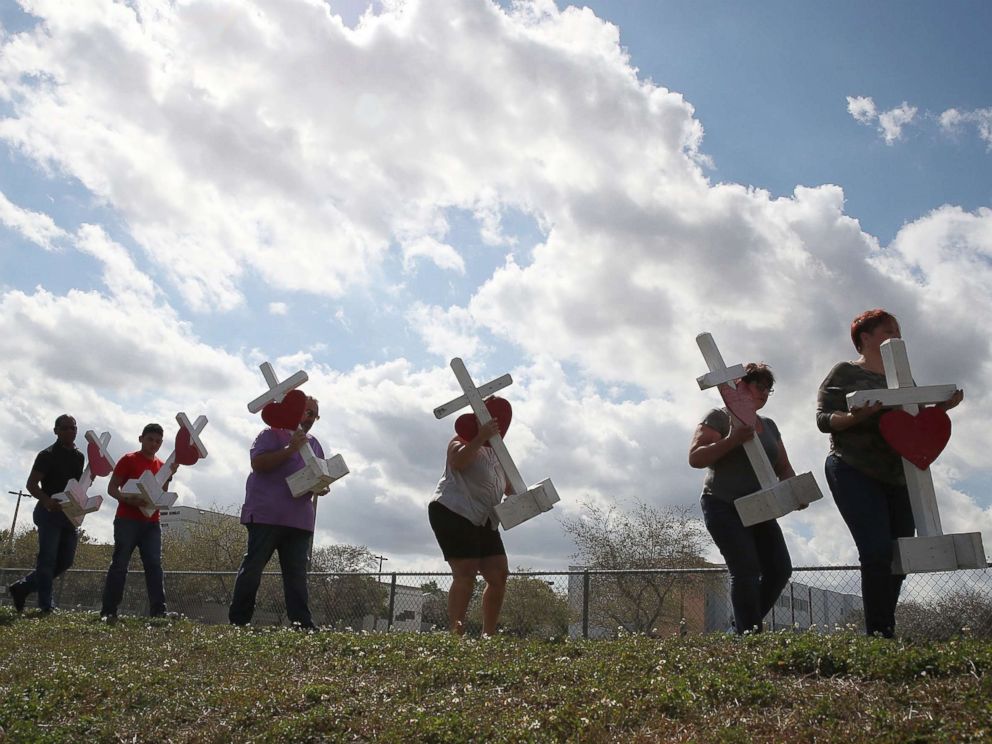 PHOTO: Volunteers carry crosses to be placed in front of the Marjory Stoneman Douglas High School, Feb. 18, 2018, in Parkland, Fla.