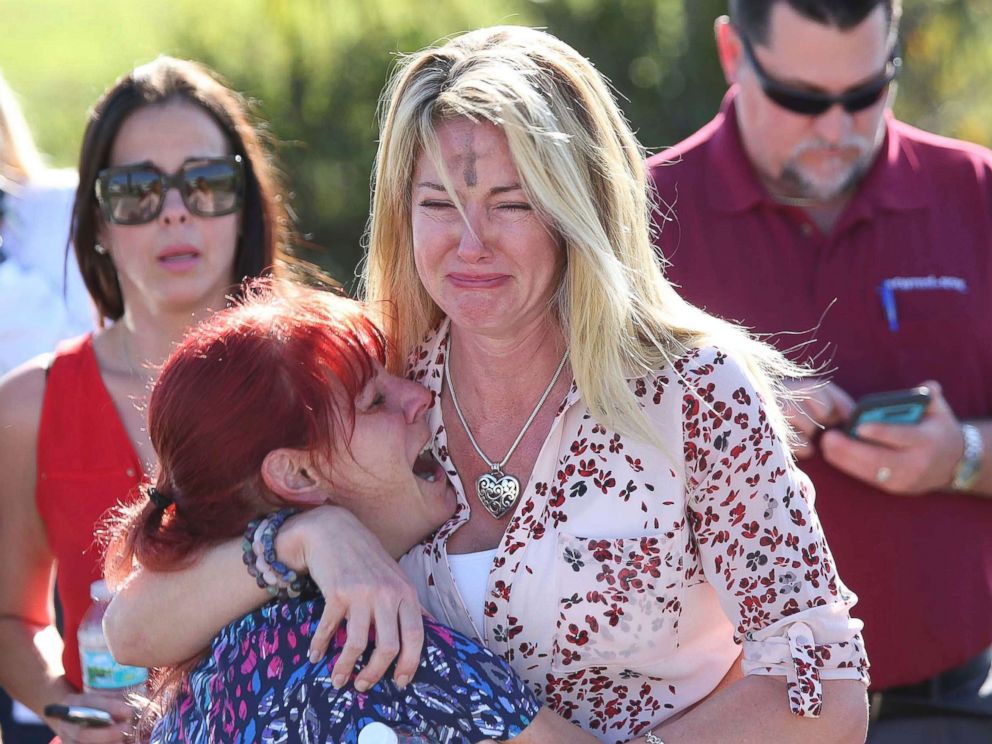 FOTO: as mulheres se abraçam em uma área de espera para pais de estudantes após um tiroteio no Marjory Stoneman Douglas High School em Parkland, Flórida, 14 de fevereiro de 2018.