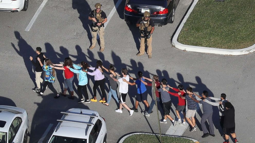 People are brought out of the Marjory Stoneman Douglas High School after a shooting at the school on Feb. 14, 2018 in Parkland, Fla.