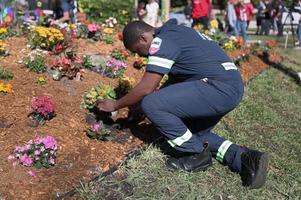 PHOTO: Devon Fuller places a plant in the ground at a garden setup in memory of those lost a year ago during a mass shooting at Marjory Stoneman Douglas High School, Feb. 14, 2019 in Parkland,  Fla.
