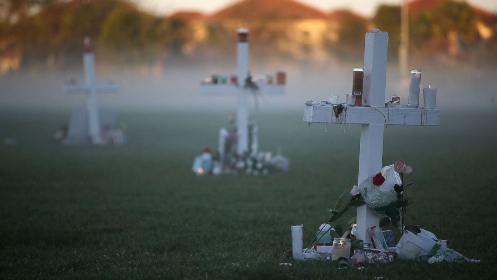 PHOTO: Candles that were placed on crosses still glow after last nights vigil for victims of the mass shooting at Marjory Stoneman Douglas High School, at Pine Trail Park, Feb. 16, 2018, in Parkland, Fla. 