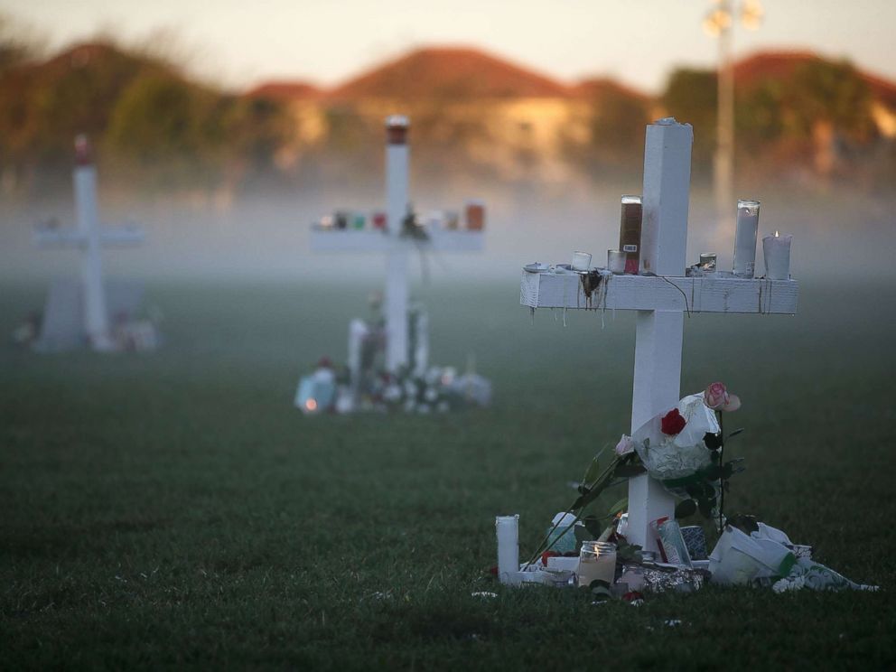 PHOTO: Candles that were placed on crosses still glow after last nights vigil for victims of the mass shooting at Marjory Stoneman Douglas High School, at Pine Trail Park, Feb. 16, 2018, in Parkland, Fla.