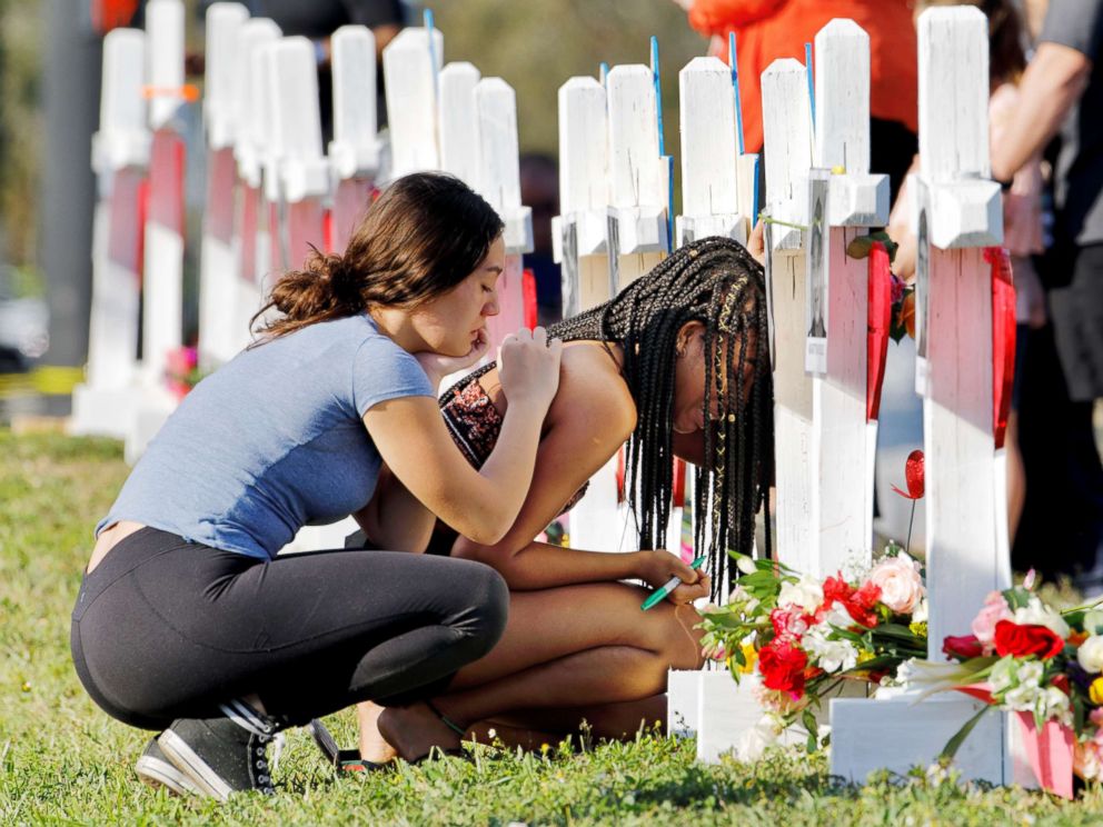PHOTO: A senior at Marjory Stoneman Douglas High School weeps in front of a cross and Star of David for shooting victim Meadow Pollack while a fellow classmate consoles her at a memorial by the school in Parkland, Fla., Feb. 18, 2018.