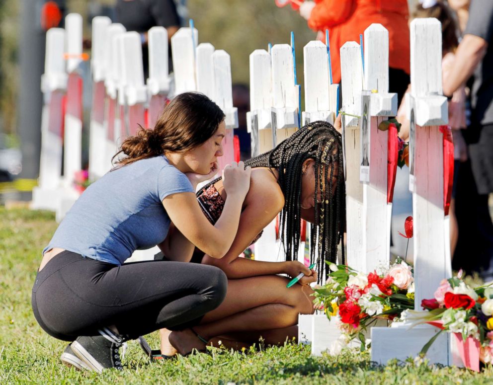 PHOTO: A senior at Marjory Stoneman Douglas High School weeps in front of a cross and Star of David for shooting victim Meadow Pollack while a fellow classmate consoles her at a memorial by the school in Parkland, Fla., Feb. 18, 2018.