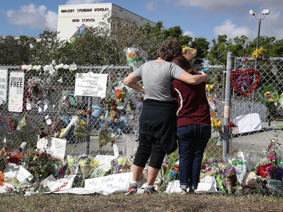 PHOTO: Margarita Lasalle, right, and Joellen Berman look at the memorial in front of Marjory Stoneman Douglas High School, on Feb. 23, 2018, after the mass shooting on campus in Parkland, Fla, Feb. 14.