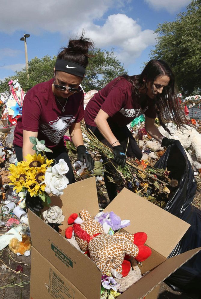 PHOTO: Rachel Polakoff and Lenzai Cutler remove items from the memorial site for the victims of the Marjorie Stoneman Douglas High School shooting in Parkland, Fla., March 29, 2018.