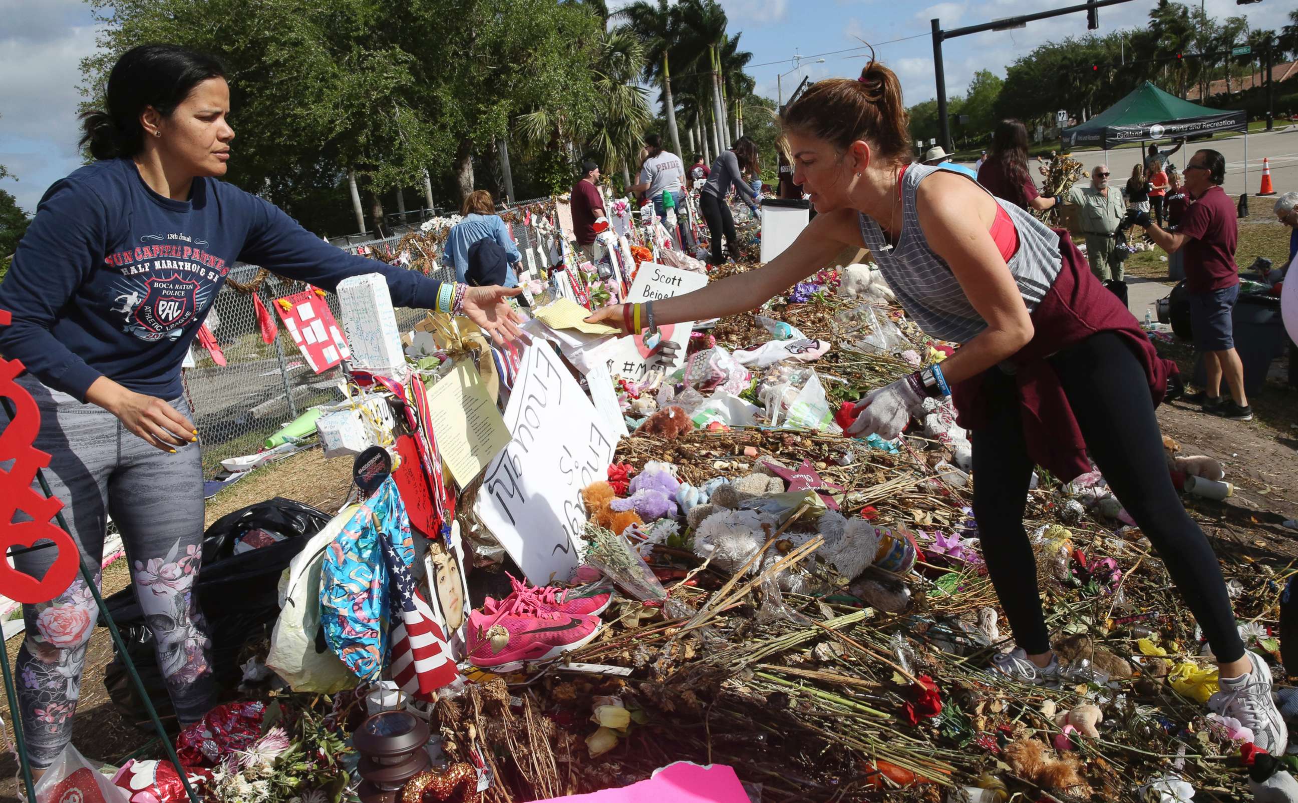 PHOTO: Patricia Padauy, right, passes a handwritten note to her friend Sharamy Angarita, as they clean and sort out items at the memorial site of Padauy's son Joaquin Oliver in Parkland, Fla., March 28, 2018.