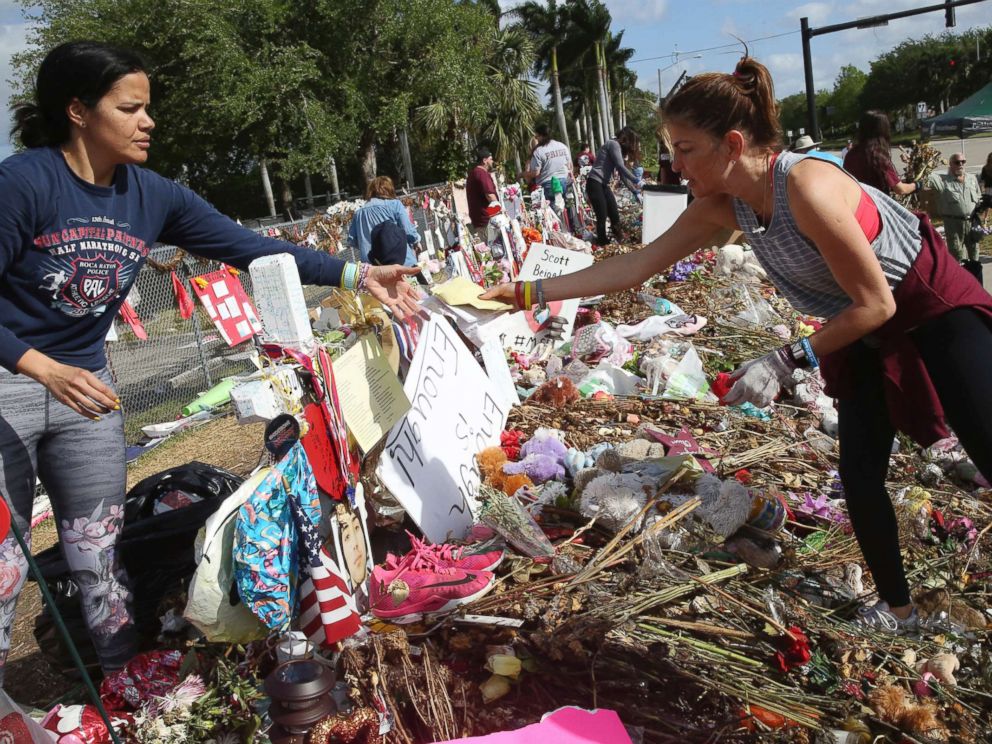 PHOTO: Patricia Padauy, right, passes a handwritten note to her friend Sharamy Angarita, as they clean and sort out items at the memorial site of Padauys son Joaquin Oliver in Parkland, Fla., March 28, 2018.