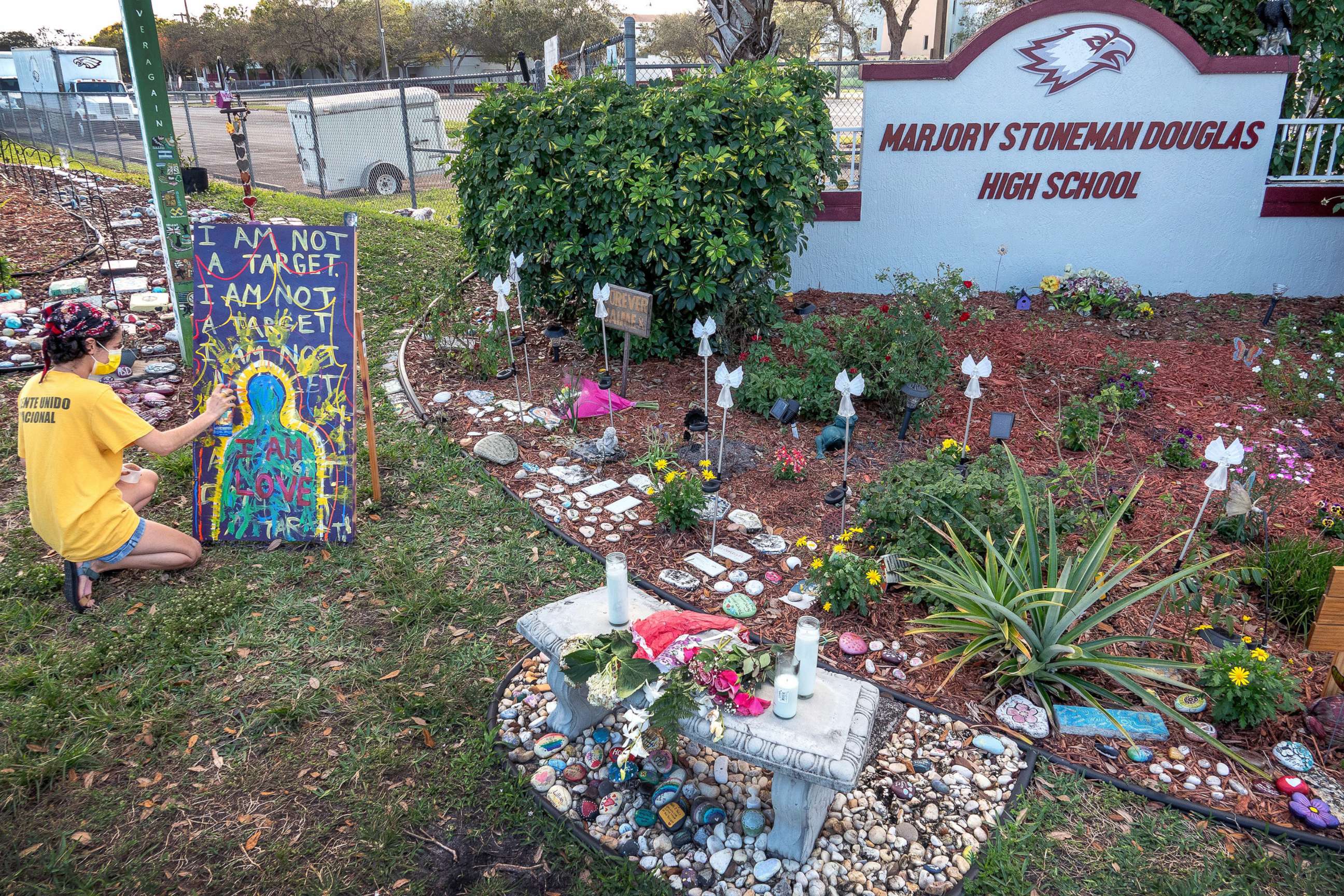 PHOTO: Victoria Rosa paints a poster in honor of the Parkland shooting victims at the makeshift memorial in front of the Marjory Stoneman Douglas High School in Parkland, Fla., Feb. 11, 2021.