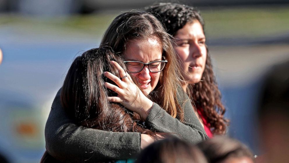 Students released from a lockdown embrace following a shooting at Marjory Stoneman Douglas High School in Parkland, Fla., Feb. 14, 2018.