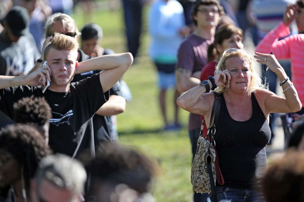 PHOTO: People wait for word from Stoneman Douglas High School students in a waiting area just south of the campus in Parkland, Fla., after a shooting on Feb. 14, 2018.